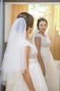 Beautiful young bride in wedding dress looking in the mirror Royalty Free Stock Photo