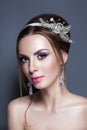 Beautiful young bride with wedding makeup on studio background