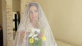 Portrait of a bride in wedding veil with a flowers