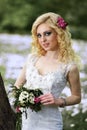 Beautiful young bride in white dress with bouquet in summer green park Royalty Free Stock Photo