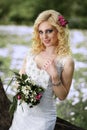 Beautiful young bride in white dress with bouquet in summer green park Royalty Free Stock Photo