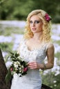 Beautiful young bride in white dress with bouquet in summer green park Royalty Free Stock Photo