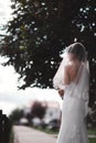 Beautiful young bride in a white luxury dress and in a bridal veil with a bouquet of flowers posing outdoor. wedding portrait. Royalty Free Stock Photo