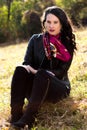 Autumn brunette is sitting in the park in sunshine