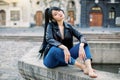 Beautiful young brunette Asian woman, dressed in jeans and black leather jacket, posing in the center of the old Royalty Free Stock Photo