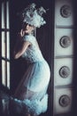 Beautiful young brunette bride wearing white dress and wreath of flowers sits on a chair. Royalty Free Stock Photo