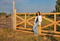 Beautiful young caucasian woman standing at the ranch gate Royalty Free Stock Photo