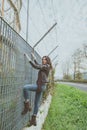 Beautiful young brunette climbing over a fence Royalty Free Stock Photo