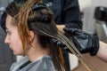 beautiful young brunette girl sitting on the procedure of hair coloring at the best master. Royalty Free Stock Photo