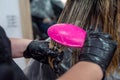 beautiful young brunette girl sitting on the procedure of hair coloring at the best master. Royalty Free Stock Photo