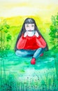 A beautiful young brunette with long hair, in a red sweater and blue jeans sits on the green grass in the forest. He holds a Cup Royalty Free Stock Photo