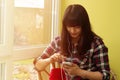 Beautiful young brunette in a plaid shirt uses a smartphone Royalty Free Stock Photo