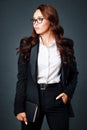 This is a beautiful young brunette woman in a business classic suit and glasses. Studio portrait of a business woman Royalty Free Stock Photo