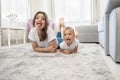 Beautiful young brunette woman with cute baby girl wearing jeans and white t-shirts lying on the floor in bright Royalty Free Stock Photo