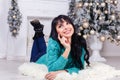 Beautiful young woman lies on the floor indoors in a christmas i Royalty Free Stock Photo