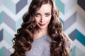 Beautiful young brunette woman with long curly hair and evening makeup, fashion beauty portrait Royalty Free Stock Photo