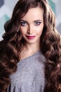 Beautiful young brunette woman with long curly hair and evening makeup, fashion beauty portrait Royalty Free Stock Photo