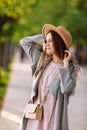 Beautiful young brunette woman with long hair flying in the wind and brown hat in park in summer. Head shot of gorgeous Royalty Free Stock Photo