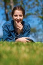 Beautiful young brunette woman lying on the green grass Royalty Free Stock Photo