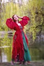 Young  brunette woman in red gown walking barefoot in nature Royalty Free Stock Photo