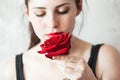 Beautiful young brunette Woman with red lips and red rose in her hand near the face as a symbol of love and care on St Royalty Free Stock Photo