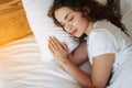 Beautiful young brunette woman sleeping in a white bed. Royalty Free Stock Photo
