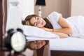 Beautiful young brunette woman sleeping in a white bed at home Royalty Free Stock Photo