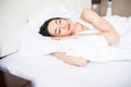 Beautiful young brunette woman sleeping in a white bed at home Royalty Free Stock Photo