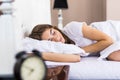 Beautiful young brunette woman sleeping in a white bed at home Royalty Free Stock Photo