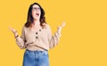 Beautiful young brunette woman wearing casual clothes and glasses crazy and mad shouting and yelling with aggressive expression Royalty Free Stock Photo