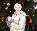 Beautiful young woman in winter clothes at christmas market drinking coffee and smiling Royalty Free Stock Photo