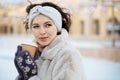 Beautiful young brunette woman in winter clothes at christmas market drinking coffee and smiling Royalty Free Stock Photo