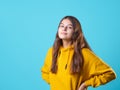 A beautiful young brunette in a yellow oversize hoodie, a positive student