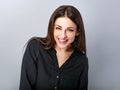 Beautiful young business toothy laughing woman in black shirt looking happy on blue grey background with empty copy space. Royalty Free Stock Photo