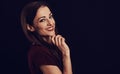 Beautiful young business toothy smiling woman thinking and looking happy in burgundy blouse and with red lipstick on dark shadow Royalty Free Stock Photo