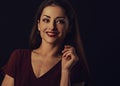 Beautiful young business toothy smiling woman thinking and looking happy in burgundy blouse and with red lipstick on dark shadow Royalty Free Stock Photo