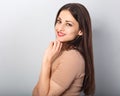 Beautiful young business woman in beige blouse thinking and looking front on blue background. Portriat