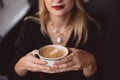 Beautiful young business woman enjoys a cup of coffee in a cafe during lunch break in autumn. Soft selective focus, artistic noise Royalty Free Stock Photo