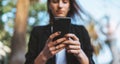 Beautiful young business woman looking smart phone outdoors. close-up of hands of a girl who writes a message in a mobile phone Royalty Free Stock Photo