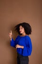 Beautiful young business woman making hand gestures. Standing against a brown background Royalty Free Stock Photo