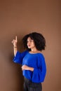 Beautiful young business woman making hand gestures. Standing against a brown background Royalty Free Stock Photo