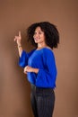 Beautiful young business woman making hand gestures. Standing against a brown background Royalty Free Stock Photo