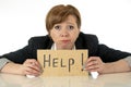 Beautiful young business woman overwhelmed and tired holding a help sign Royalty Free Stock Photo