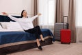 Beautiful young business woman relaxing on bed in hotel room Royalty Free Stock Photo