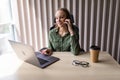 beautiful young business woman sitting at office desk and talking on phone Royalty Free Stock Photo