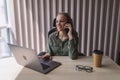 beautiful young business woman sitting at office desk and talking on phone Royalty Free Stock Photo