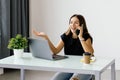 beautiful young business woman sitting at office desk and talking on phone Royalty Free Stock Photo