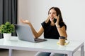 beautiful young business woman sitting at office desk and talking on phone Royalty Free Stock Photo