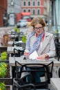 Beautiful young business woman sitting in an outdoor cafe and working with documents. Royalty Free Stock Photo