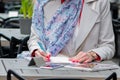 Beautiful young business woman sitting in an outdoor cafe and working with documents. Royalty Free Stock Photo